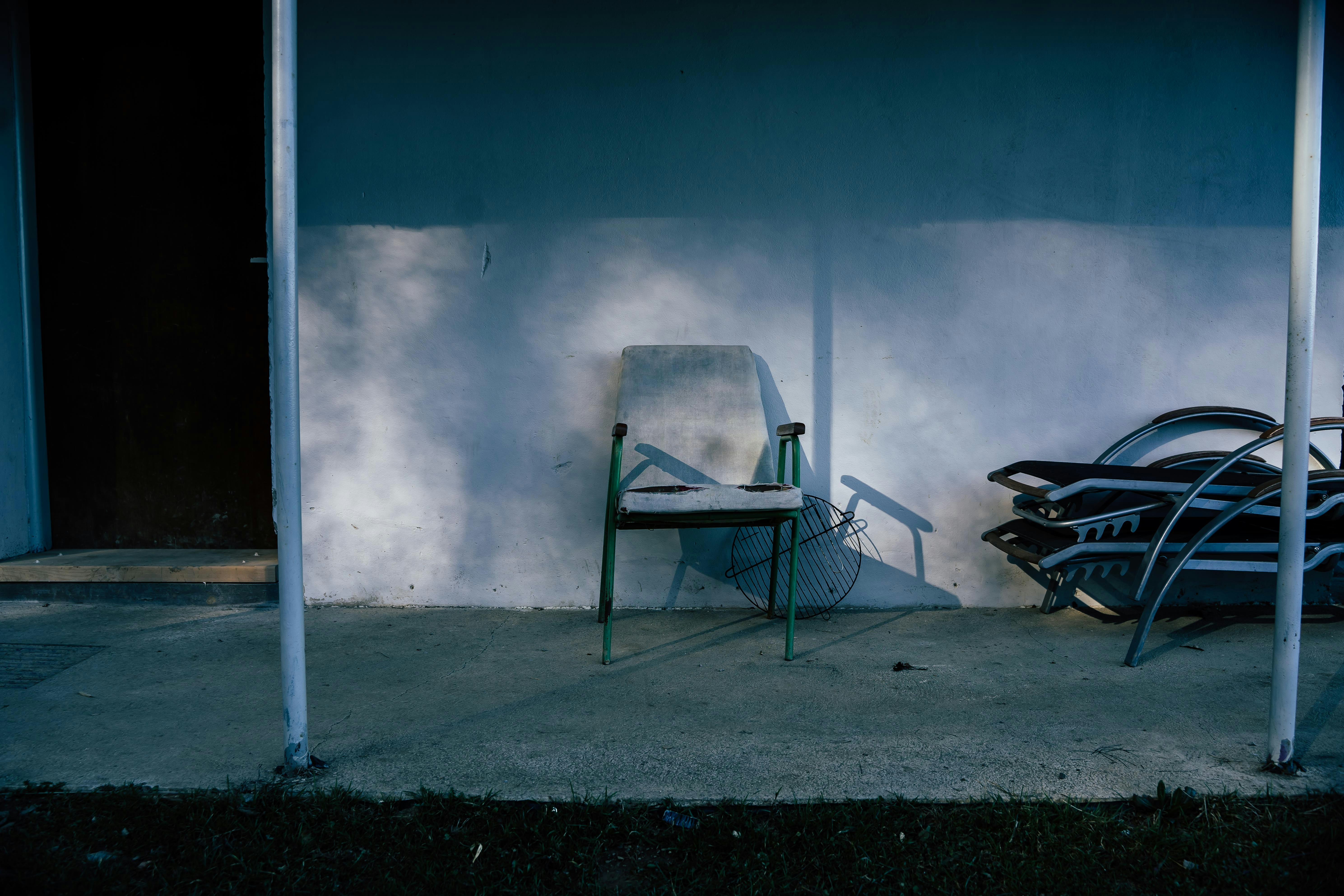 black metal bench beside white wall